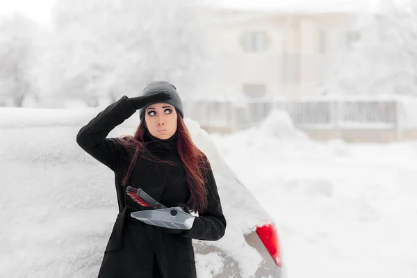 Fille avec brosse et pelle Enlever la neige de la voiture — Photo