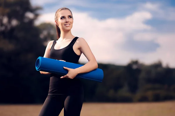 Pilates Mädchen mit Yogamatte steht draußen in der Natur — Stockfoto