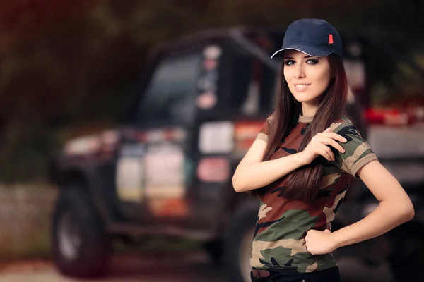 Motorista feminina em roupa do exército ao lado de um carro off-road — Fotografia de Stock