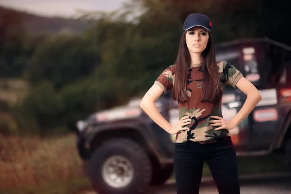 Motorista feminina em roupa do exército ao lado de um carro off-road — Fotografia de Stock