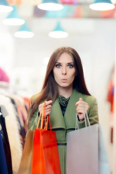 Здивована жінка в зеленому пальто в модному магазині — стокове фото