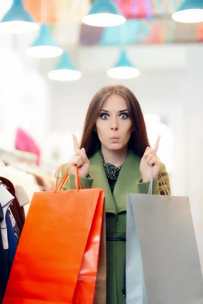 Förvånade Shopping kvinna som bär en grön kappa i modebutik — Stockfoto