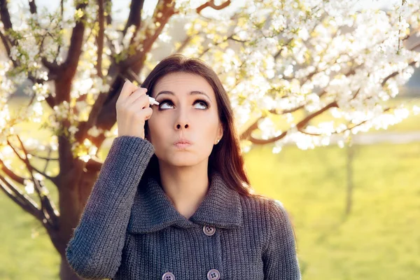 Женщина с весенней аллергией с помощью глазных капель — стоковое фото