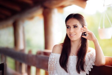 Beyaz dantel üst giyen bir gülümseyen kadın portresi