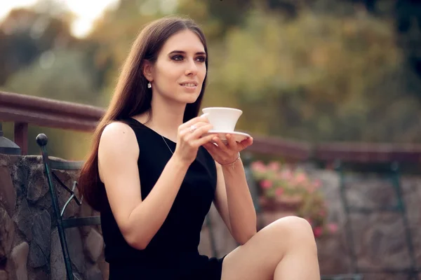 Mulher elegante bebendo um café no jardim — Fotografia de Stock