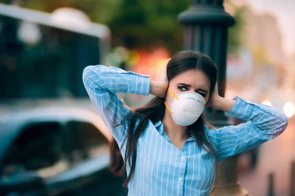 Ragazza con maschera che si copre le orecchie a causa dell'inquinamento acustico — Foto Stock