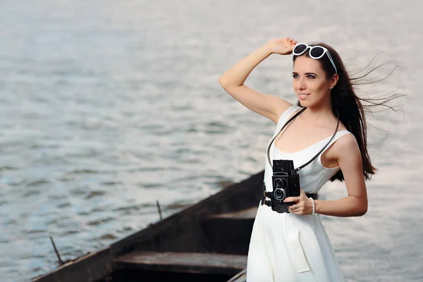 Mujer retro con cámara de fotos vintage en una playa — Foto de Stock