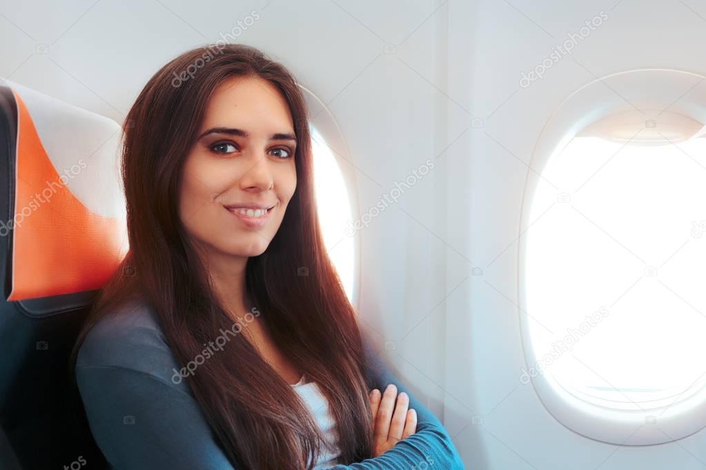 Smiling Woman Sitting By the Window on An Airplane