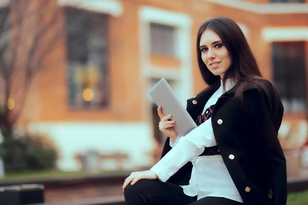 Улыбающаяся женщина с планшетным ПК в университетском городке — стоковое фото