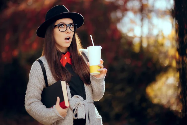 Surprised Female Student Holding a Hot Drink and a Book — Stock Photo, Image