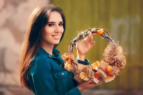 Šťastná dívka držící dekorativní podzimní věnec — Stock fotografie