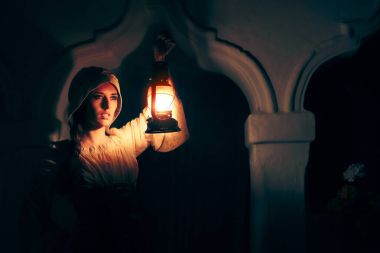 Medieval Woman with Vintage Lantern Outside at Night clipart
