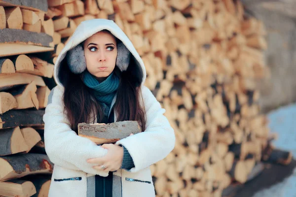 Девушка чувствует холод, держа дрова зимой — стоковое фото