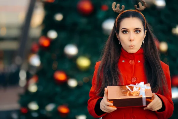 Mulher segurando caixa de presente na frente da árvore decorada de Natal — Fotografia de Stock