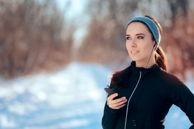 Kadın onun favori müzik çalma listesi egzersiz kış sezonu sırasında dinleme