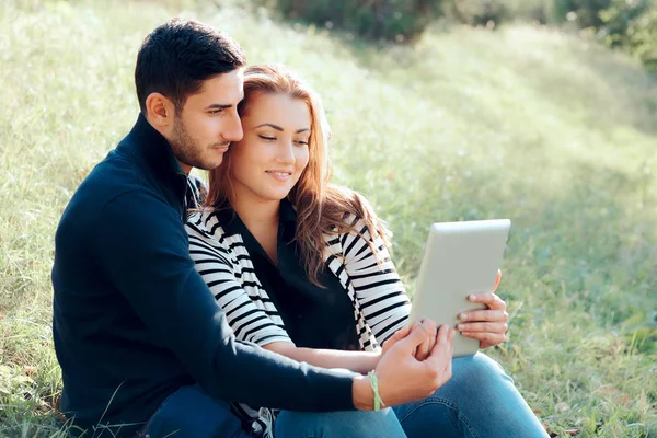 在户外约会中拥抱情侣与数字平板电脑 — 图库照片