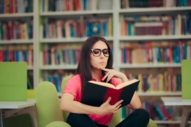 Çalışkan kıza bir kitaplığındaki kitap okuma