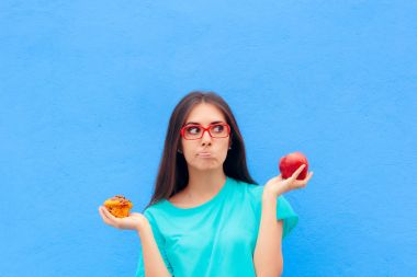 Kadın sağlıksız Muffin ve sağlıklı Apple arasında seçim yapma