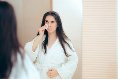 Kadın yüzünü makyaj temizleyici ile temizlik bornoz