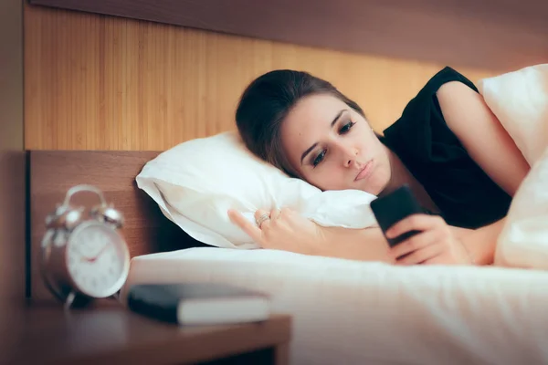Λυπημένη Γυναίκα Ελέγχοντας Τηλέφωνό Της Στο Κρεβάτι — Φωτογραφία Αρχείου
