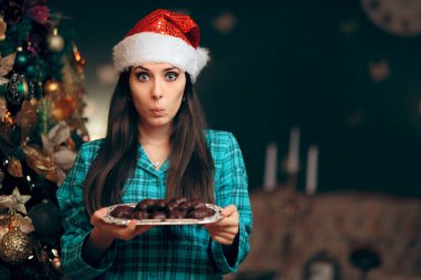 Elinde bir tepsi kurabiye tutan kadın Noel Baba 'yı bekliyor.