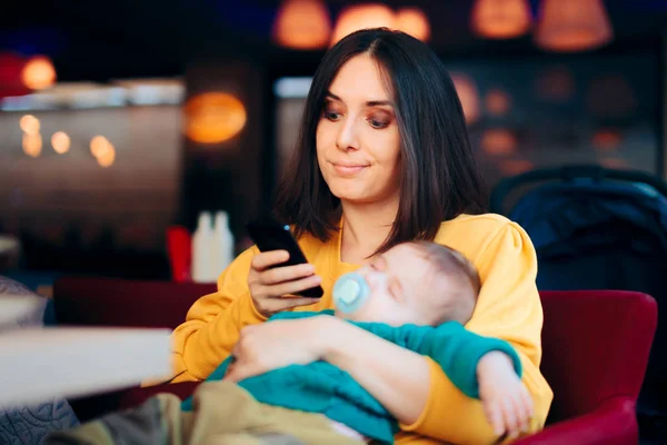 Sıkılmış Anne Bebek Uyurken Akıllı Telefonu Kontrol Ediyor — Stok fotoğraf