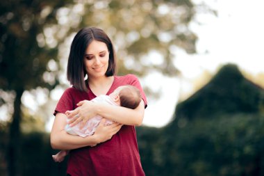 Bebeğini dışarıda tutan mutlu bir annenin portresi.