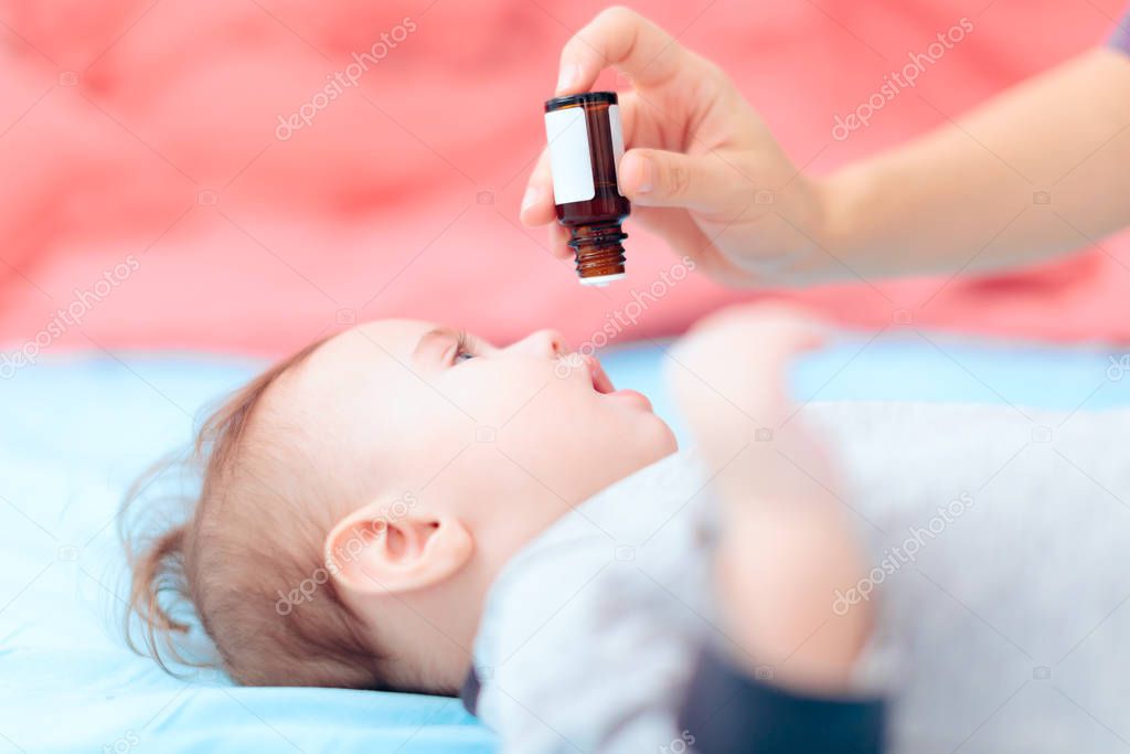 Mother Administrating Vitamin D Medicine to her Baby