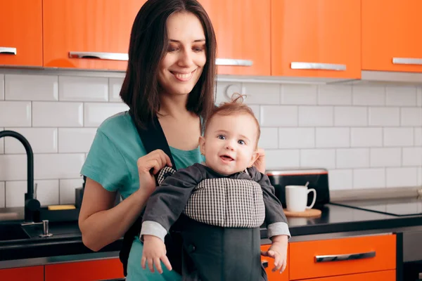 Mère Heureuse Tenant Bébé Dans Porteur Dans Cuisine — Photo