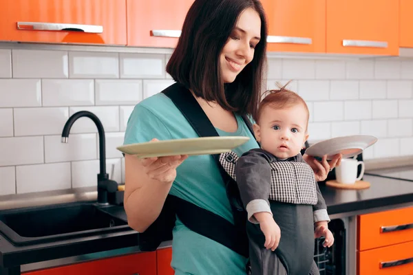 Anne Bulaşıkları Tutuyor Bebeği Taşıyıcıda — Stok fotoğraf