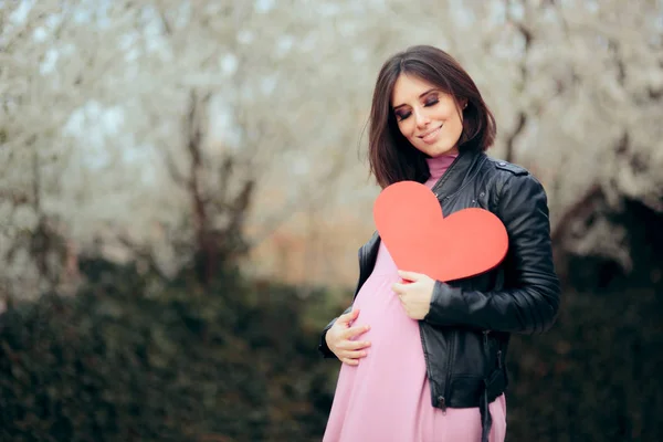Těhotná Žena Drží Červené Srdce Kvetoucí Jarní Sezóně — Stock fotografie