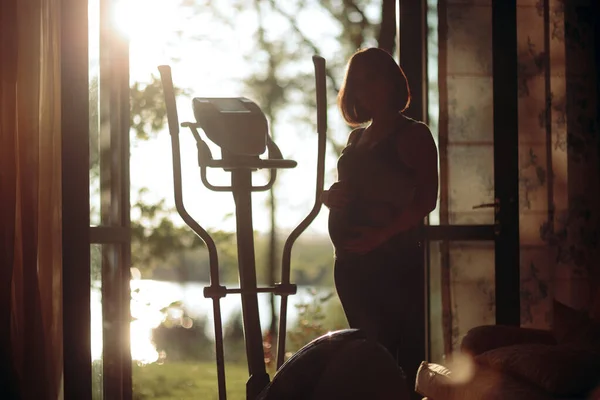 Έγκυος Γυναίκα Άσκηση Για Ελλειπτική Μηχανή Στο Σπίτι — Φωτογραφία Αρχείου