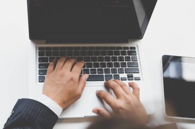 Ofiste dizüstü bilgisayarda yazarak işadamı