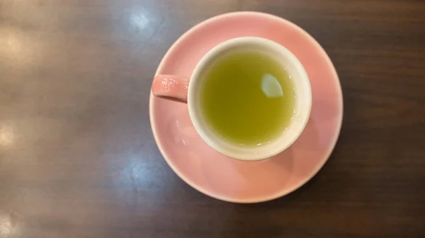 Hot green tea in pink cup — Stock Photo, Image