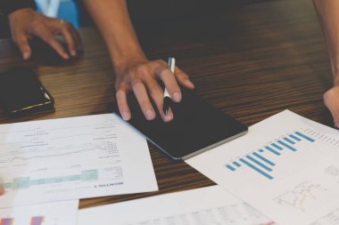 Ofisteki belge, tablet ve akıllı telefonla çalışan iş adamı