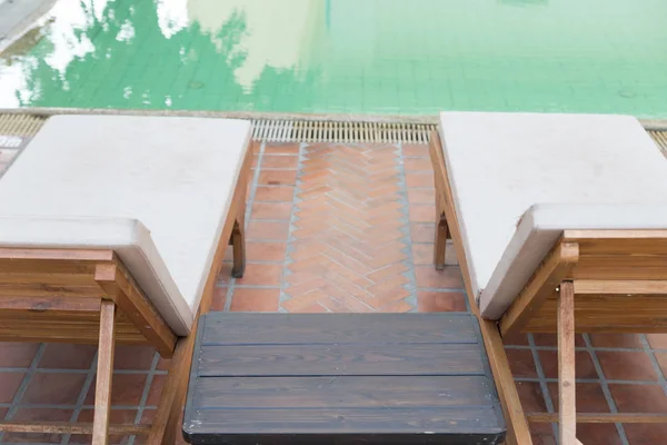 wood table and pool chair for resting and relaxing at swimming p