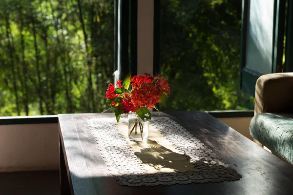Flor ixora en la mesa de madera y sofá sofá marrón en la sala de estar n —  Fotos de Stock