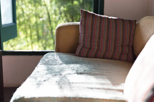 Καφέ καναπέ-κρεβάτι στο σαλόνι κοντά στο παράθυρο — Φωτογραφία Αρχείου