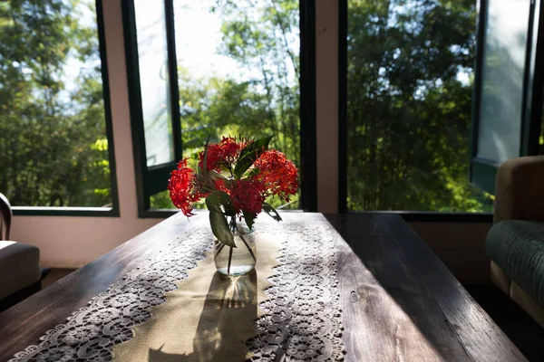 Ixora flower in vase on wood table near window — Stock Photo, Image