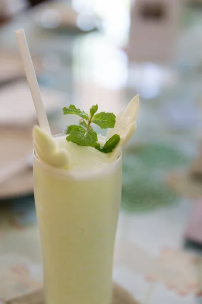 Ανεπεξέργαστα μάνγκο smoothie διακοσμημένο με φύλλα μέντας — Φωτογραφία Αρχείου