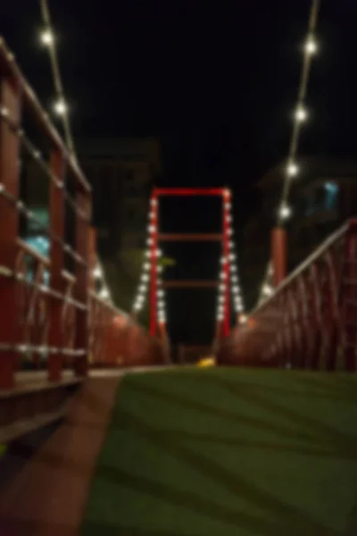 Свет на красном пешеходном мосту ночью, размытый фон — стоковое фото