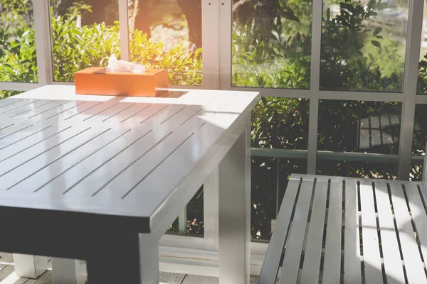 Біла лавка і стіл біля скляних дверей з видом на сад — стокове фото