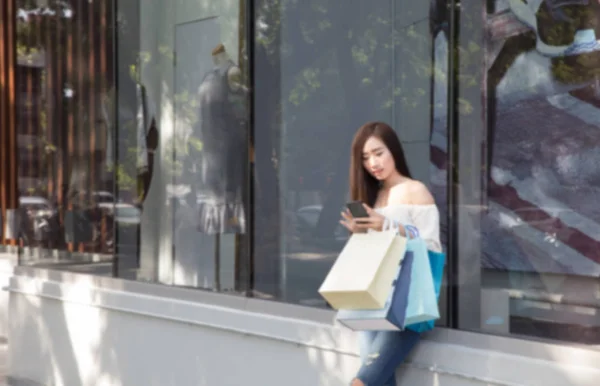 Gelukkig Aziatische vrouw met smartphone en kleurrijke tassen van de shopping bij — Stockfoto