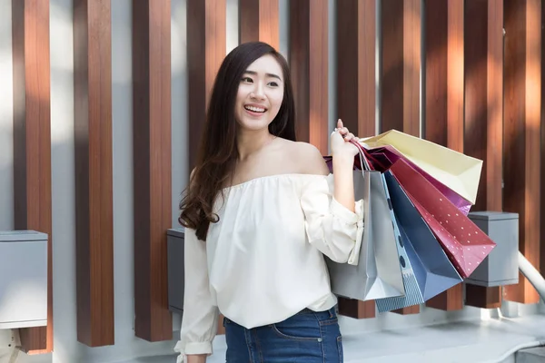 Feliz asiático mujer con colorido compras bolsas en departamento stor — Foto de Stock