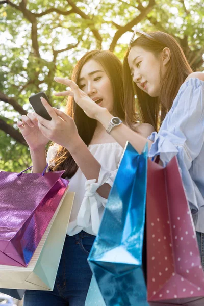 Happy Asijské žena s smartphone a barevné nákupní tašky na — Stock fotografie