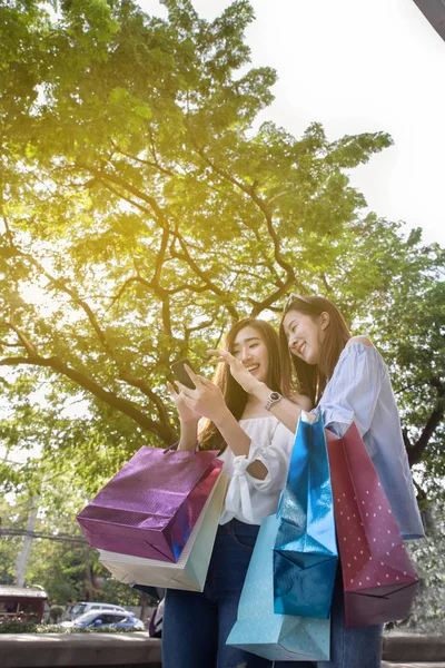 Ευτυχισμένη γυναίκα της Ασίας με smartphone και πολύχρωμες τσάντες για ψώνια στο — Φωτογραφία Αρχείου