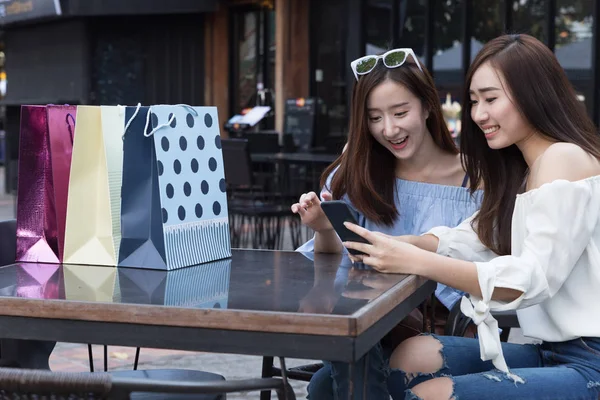 Mujer asiática feliz con teléfono inteligente y bolsas de compras de colores en — Foto de Stock