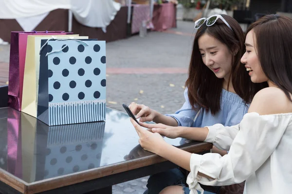 Mujer asiática feliz con teléfono inteligente y bolsas de compras de colores en — Foto de Stock