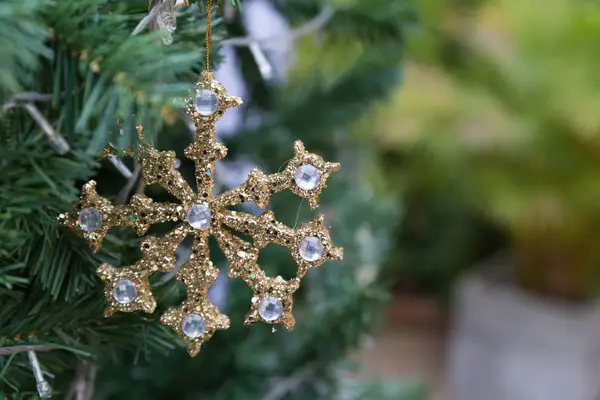 Arany fényes karácsonyi dísz lóg egy zöld fenyőfa — Stock Fotó