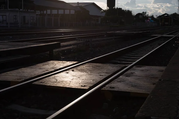 Via férrea na estação ferroviária ao pôr-do-sol — Fotografia de Stock